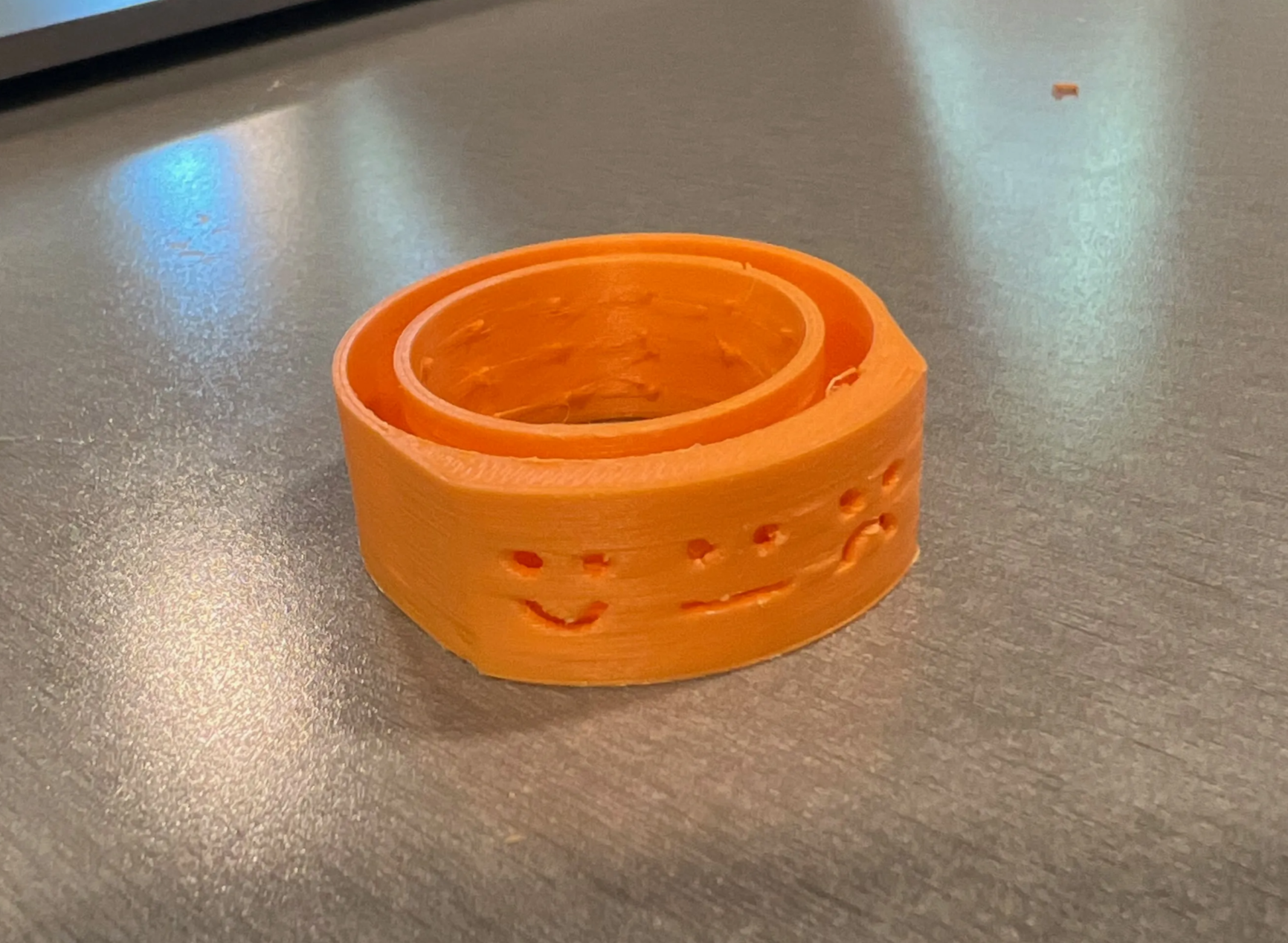 Final Glow Tap prototype on a bathroom faucet with smiley-face light openings